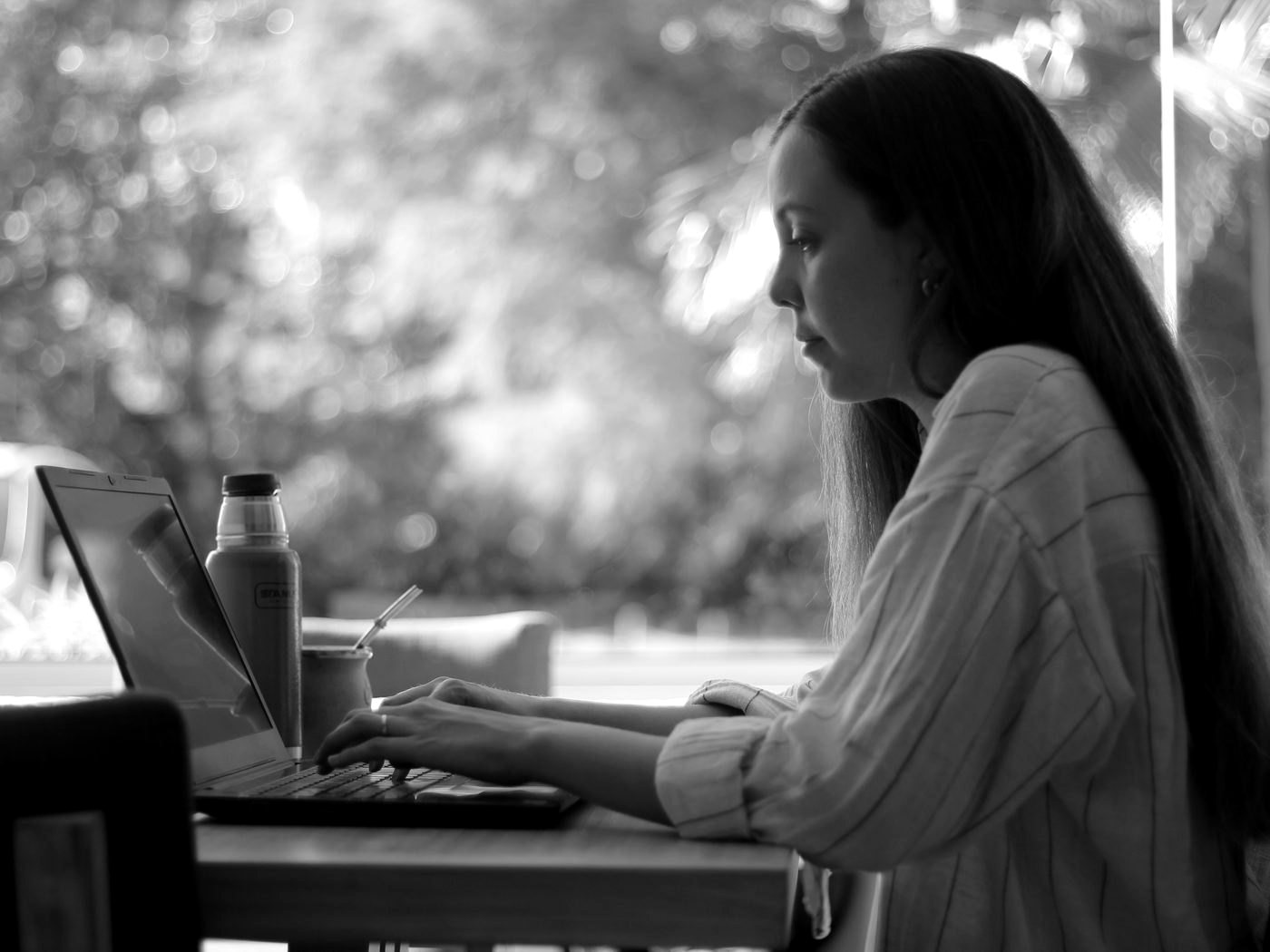 Vicky Moreno de perfil, escribiendo en la computadora con el mate al lado